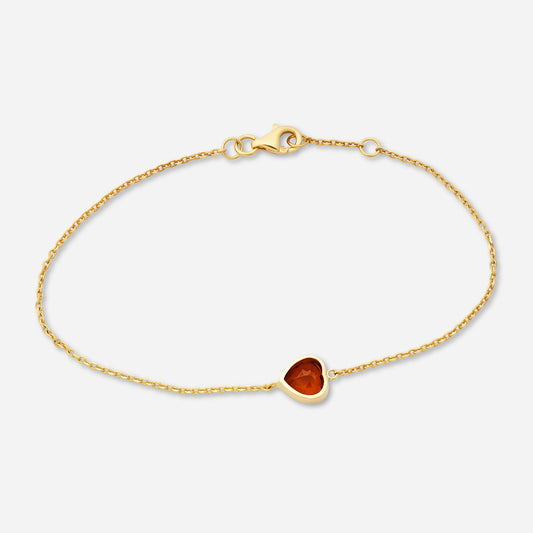 Guld armband smycken med en hjärtformad turmalin.